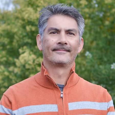 middle aged man with gray hair and orange sweater