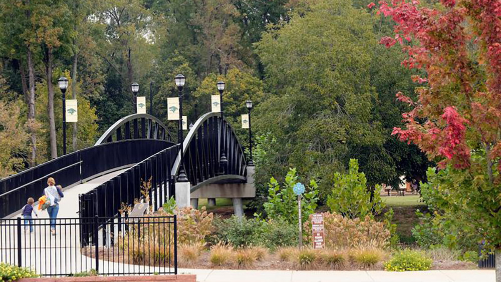 walking path bridge with adult and child walking over it