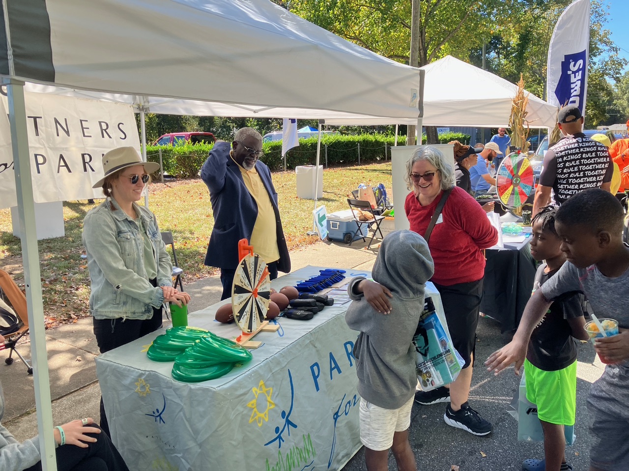 partners for parks booth with children talking to adults at the booth