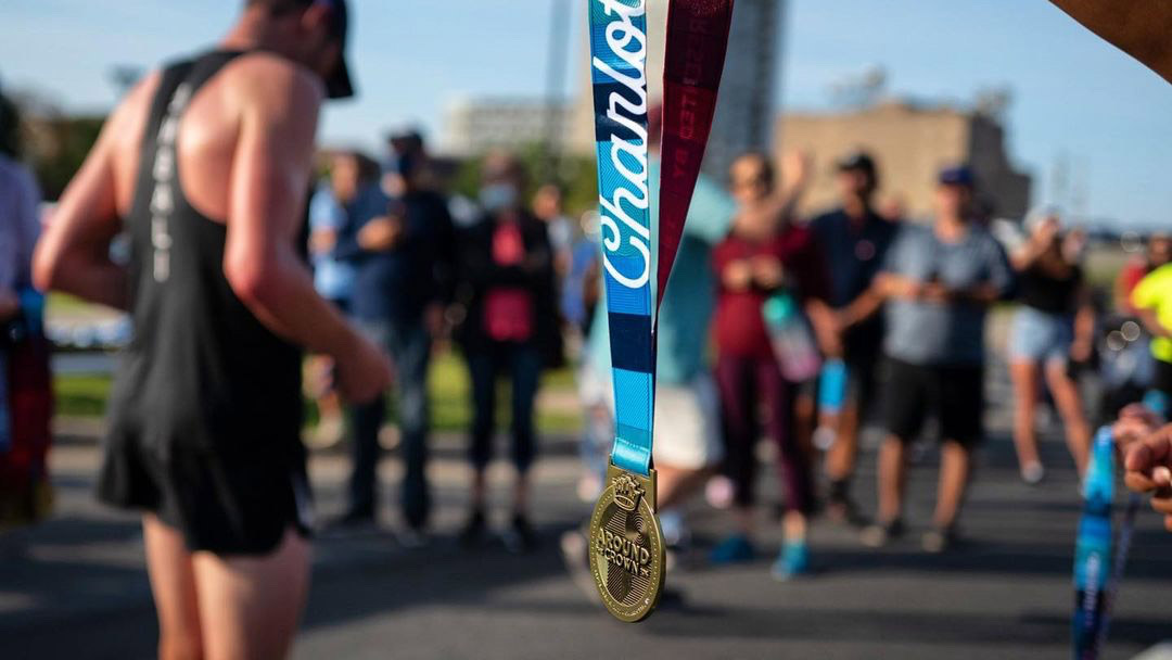running medal with group of out of focus runners in the background