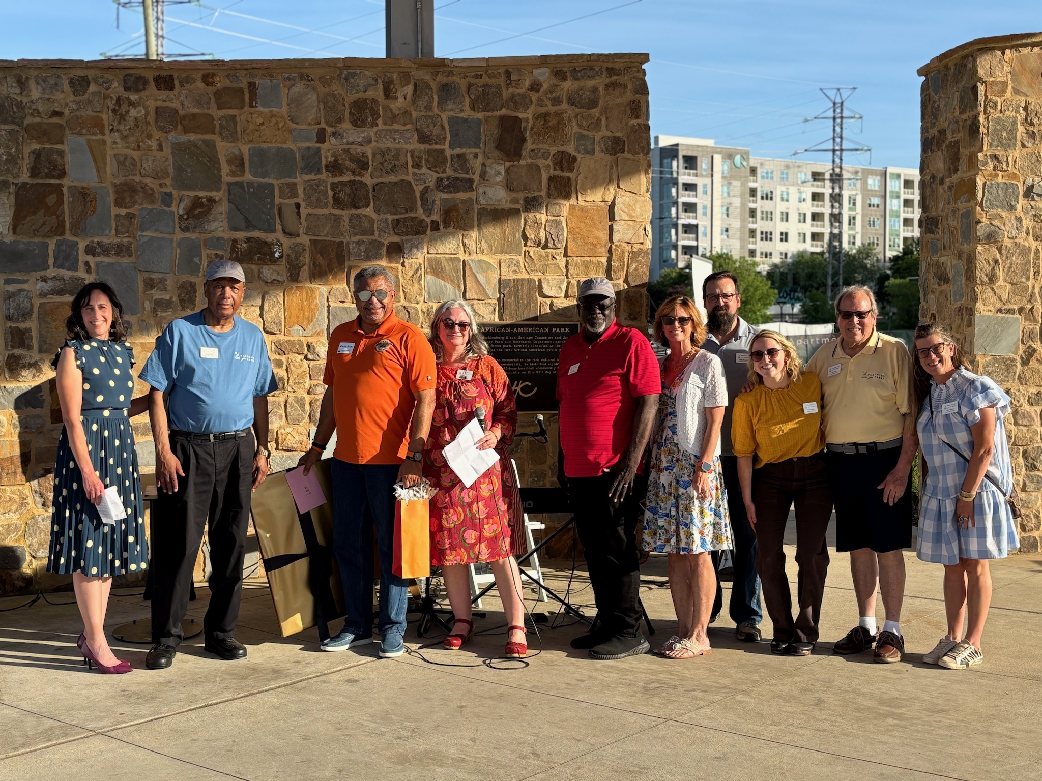 Group of people with nametags standing in front of a stone wall