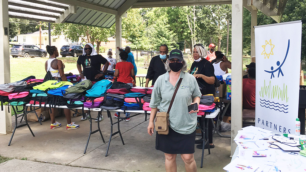 people at a booth giving away backpacks