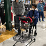 masked adult and child shopping in a mall
