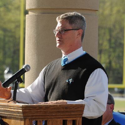 Man speaking into a microphone at a podium