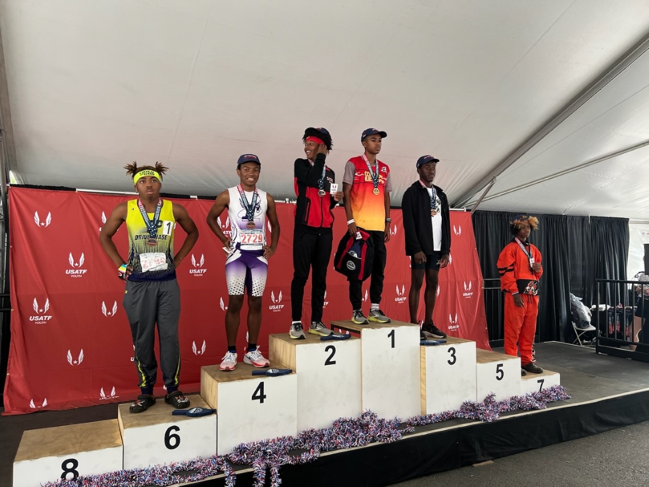 podium with award winners for first through seventh place