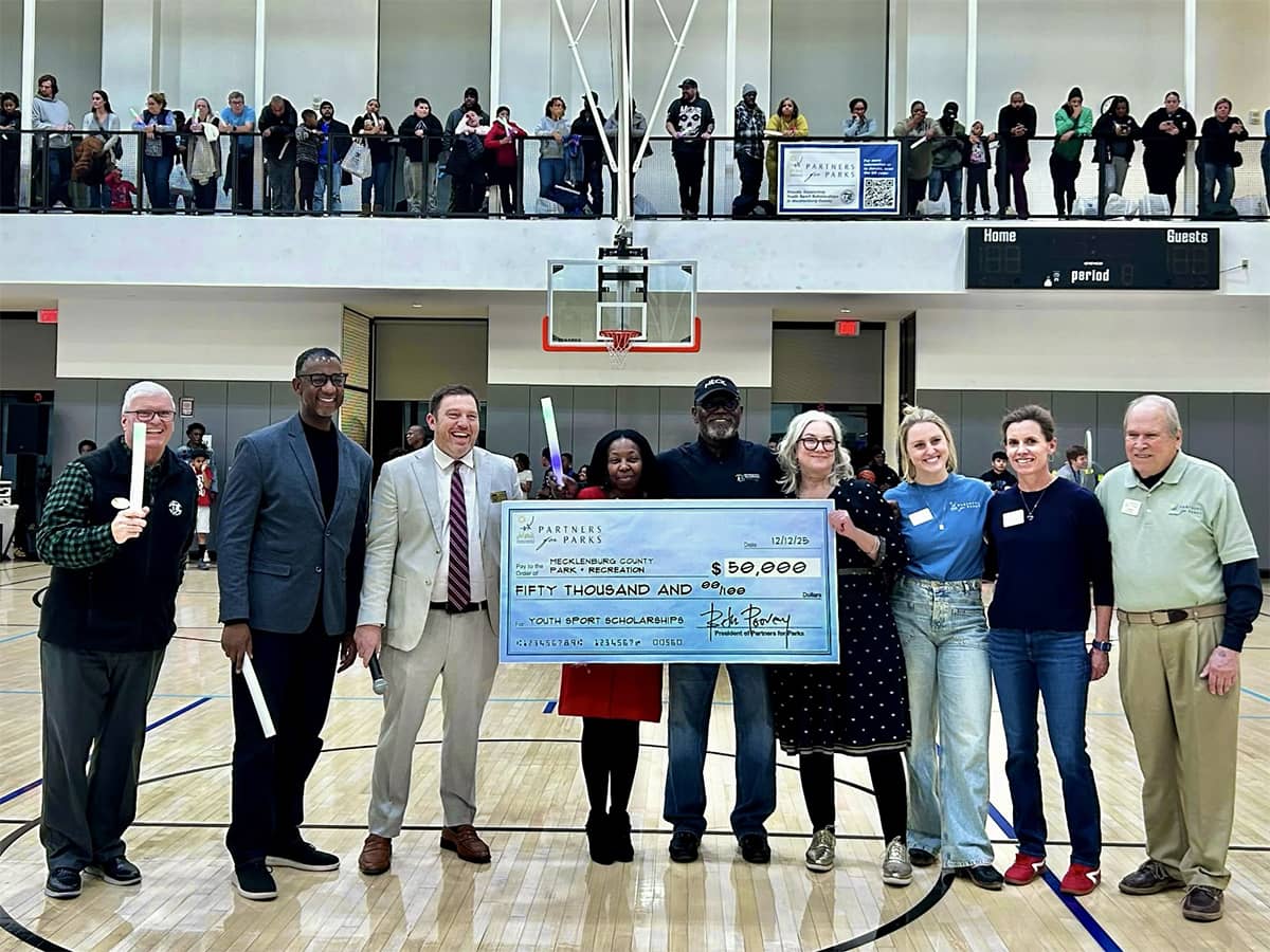 group holding a large check in a gymnasium